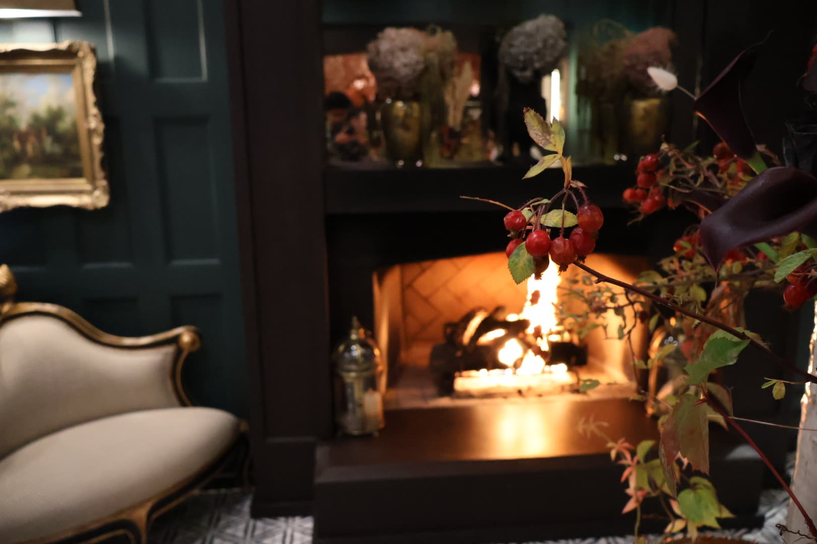 Red berries in foreground with warm fireplace glow behind